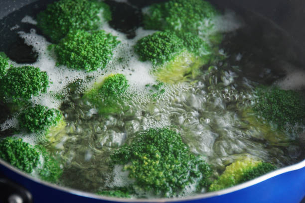 Boil the broccoli in boiling water. Boil the broccoli in boiling water. boiled stock pictures, royalty-free photos & images