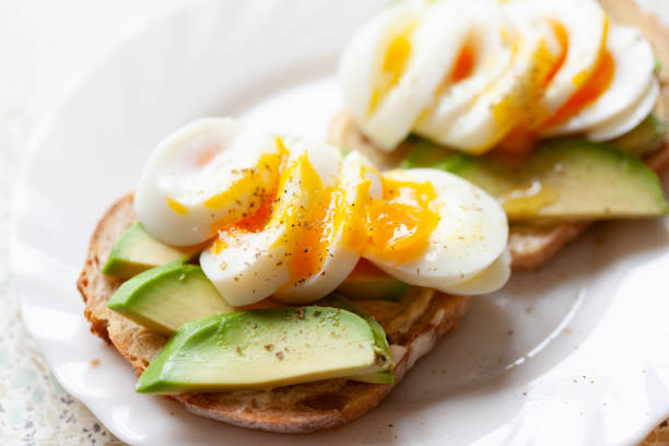 Boiled eggs and avocado on sourdough bread - close-up stock photo