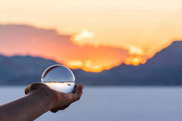 ボンネビルソルトフラットカラフルな風景ボケ背景ソルトレイクシティ、ユタ州ソルトレークシティの近くにクリスタルボールを保持し、山の景色と夕日 - 水晶 ストックフォトと画像