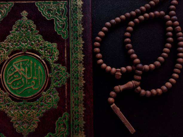 A book Al-Quran and beads on the black table Close-up a book Al-Quran and beads on the black table during Ramadan eid al adha calligraphy stock pictures, royalty-free photos & images