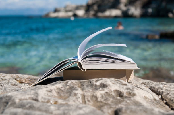 Book at beach - summer reading stock photo