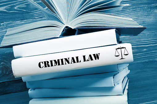 Law concept - Law book with Criminal Law  word on table in a courtroom or law enforcement office. Toned image.