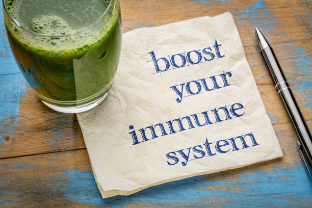boost your immune system boost your immune system - inspirational handwriting on a napkin with a glass of fresh, green, vegetable juice, healthy lifestyle and wellbeing concept immune system stock pictures, royalty-free photos & images