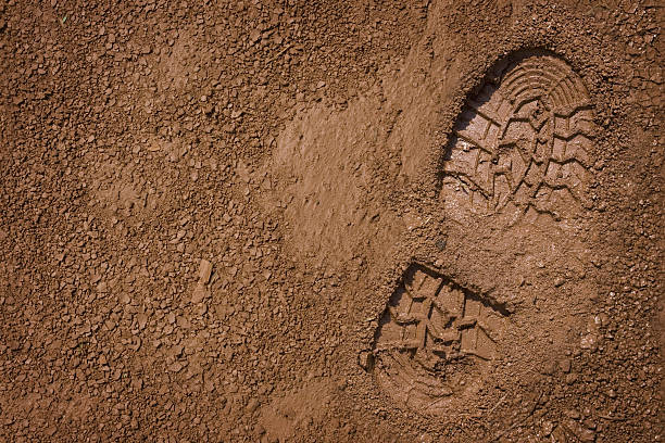 bootprint on mud - muddy shoes stockfoto's en -beelden
