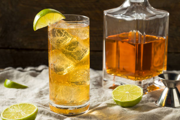 Boozy Whiskey Ginger Ale Cocktail Boozy Whiskey Ginger Ale Cocktail with LIme highball glass stock pictures, royalty-free photos & images