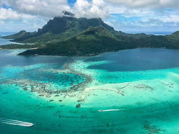 Bora Bora Island Aerial View French Polynesia Aerial view of Bora Bora island over beautiful turquoise lagoon with speedboats to volcanic Mount Otemanu. Bora Bora, Society Islands, French Polynesia. atoll stock pictures, royalty-free photos & images