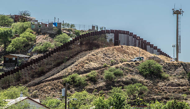 Border fence separating Mexico and the United States Border fence looking from Nogales Arizona into Nogales in Sonora Mexico border patrol stock pictures, royalty-free photos & images
