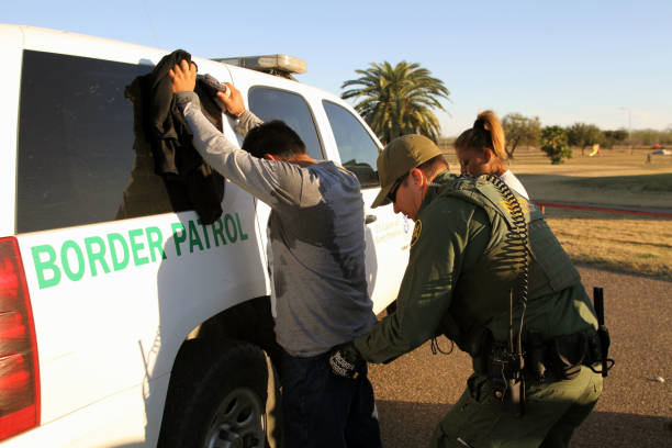 Border Patrol, Rio Grande Valley, Texas, Feb. 9, 2016 Rio Grande City, Texas, USA - February 9, 2016: A Border Patrol agent takes a Mexican man into custody for illegally entering the U.S. by crossing the Rio Grande River in the Rio Grande Valley in far south Texas. A continuous game of cat and mouse plays out along the river twenty four hours a day. border patrol stock pictures, royalty-free photos & images