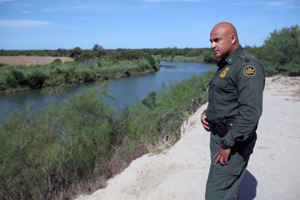 Border Patrol, Rio Grande Valley, Texas, Sept. 21, 2015 Roma, Texas, USA - September 21, 2015:  A Border Patrol agent looks across the Rio Grande River towards the Mexican town of Miguel Aleman.  This stretch of the river is notorious for being used to ship drugs, primarily marijuana, to the United States. border patrol stock pictures, royalty-free photos & images