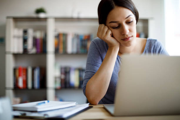 Bored woman working from home stock photo
