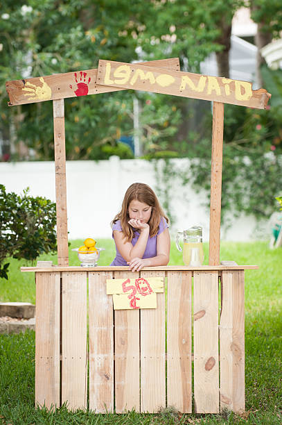 Bored young girl with no customers at her lemonade stand stock photo