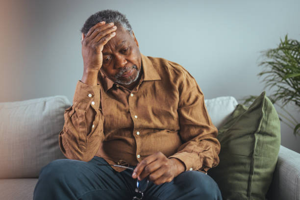 Boring tired sad mature man depressed lonely not having visitors to his children. Boring tired sad mature man depressed lonely not having visitors to his children. The concept of health problems. Locks, unemployment, useless man at a social distance. sad old black man stock pictures, royalty-free photos & images