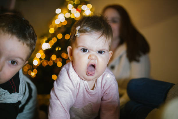 Born to be wild Cute baby girl making funny faces in front of the Christmas tree displeased photos stock pictures, royalty-free photos & images