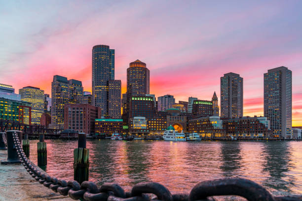 Boston skyline and Fort Point Channel at sunset as viewed fantastic twilight or dusk time from Fan Pier Park in Boston, Massachusetts, USA. United state downtown beautiful colorful skyline. stock photo
