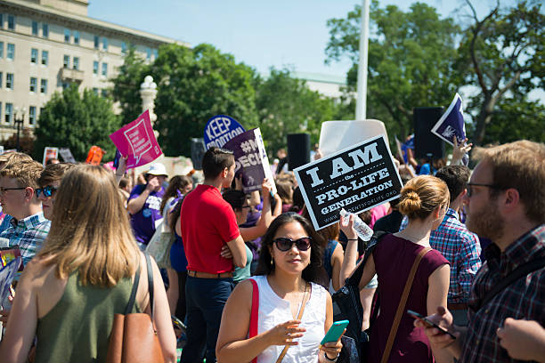 Both sides of abortion debate outsite US Supreme Court Washington DC, USA - June 27, 2016: Pro-choice and pro-life supporters stand in front of the U.S. Supreme Court after the court, in a 5-3 ruling in the case Whole Woman's Health v. Hellerstedt, struck down a Texas abortion access law. abortion protest stock pictures, royalty-free photos & images