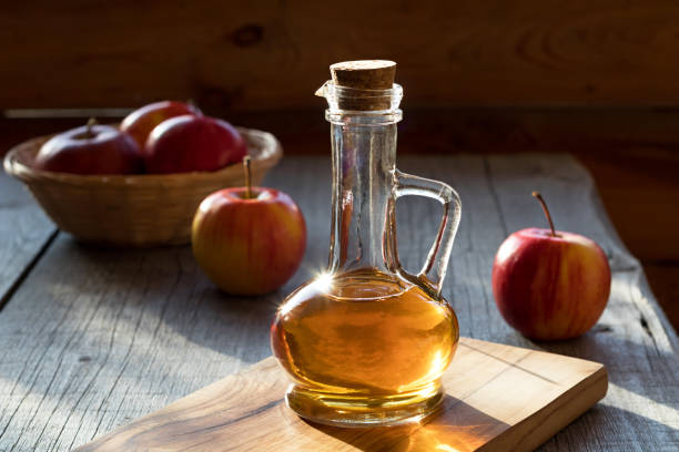 A bottle of apple cider vinegar with apples stock photo