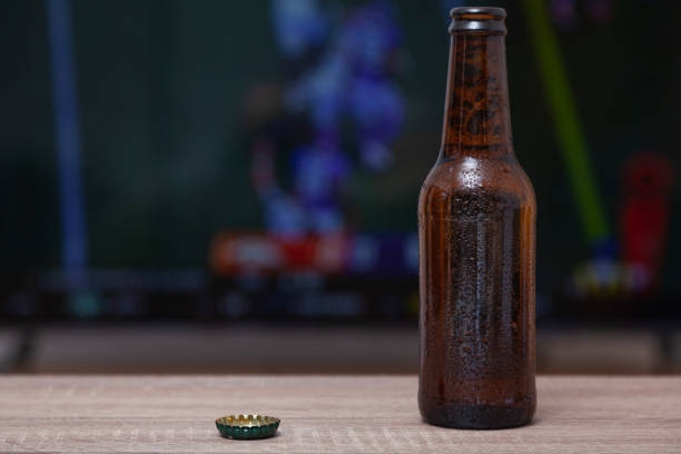 A bottle of beer in front of a TV stock photo