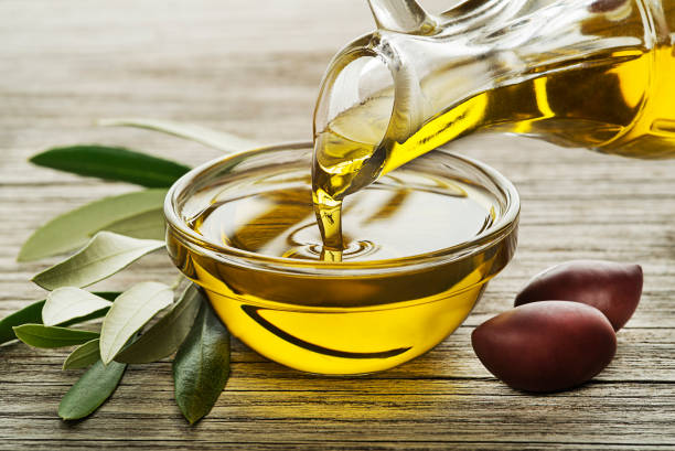 Bottle of Olive oil pouring close up stock photo