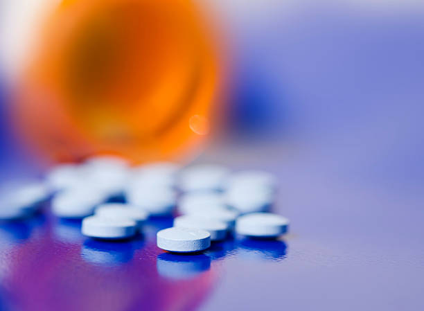 Bottle of pills on blue background Bottle of pills on blue background generic drug stock pictures, royalty-free photos & images