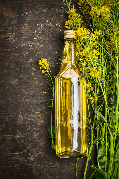 Bottle of Rape oil on rustic wooden background, top view stock photo