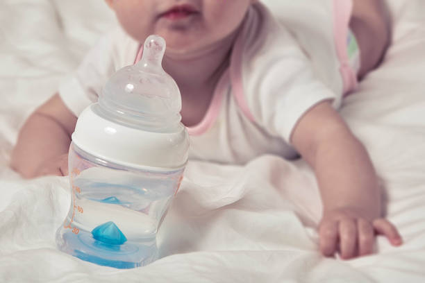 Bottle of water for baby. Infant child on blurred background stock photo