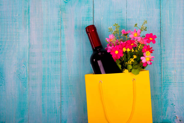 bottle of wine and flowers in the package on wooden background, space for text bottle of wine and flowers in the package on wooden background, space for text happy birthday wine bottle stock pictures, royalty-free photos & images