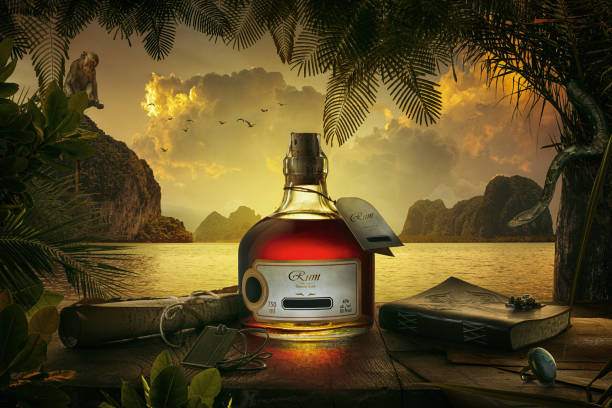 bottle on shore NO LOGO OR TRADEMARK! SELF MADE LABELS!  view of bottle of rum  on sunset background. rum stock pictures, royalty-free photos & images