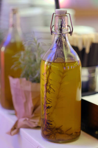 Bottle with olive oil with green sprig of rosemary herb inside. stock photo