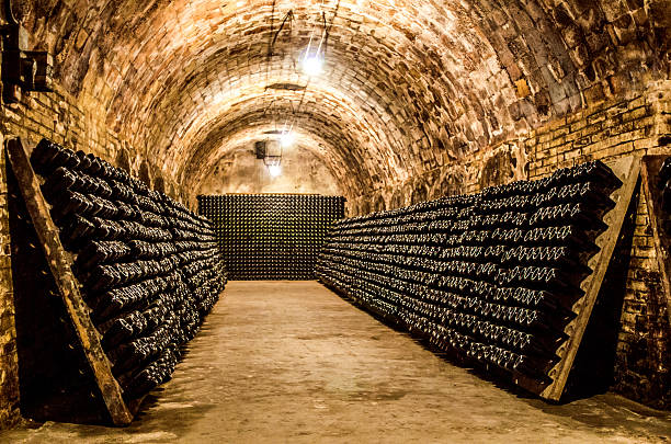 bottles in a cellar horizontal champagne (cava) bottles maturing in cellar cellar stock pictures, royalty-free photos & images