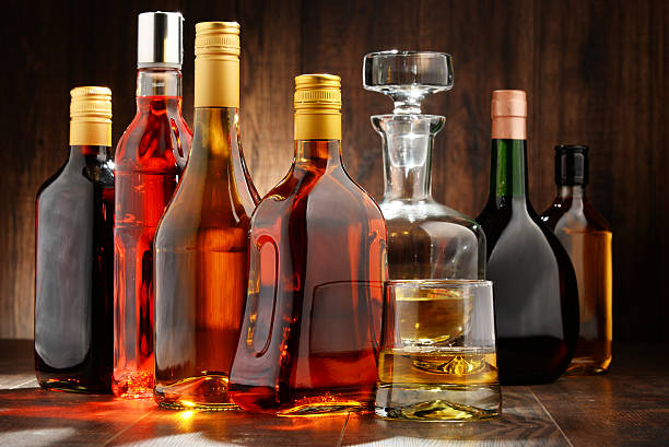 bottles of assorted alcoholic beverages - fles stockfoto's en -beelden