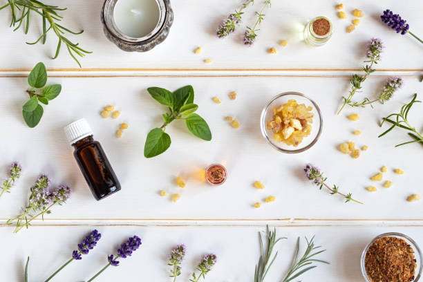 flessen van etherische olie met wierook, lavendel, tijm en andere verse kruiden - essential oils smell stockfoto's en -beelden