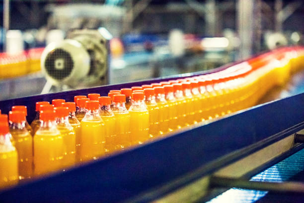 Bottles on Conveyor Belt in Factory Bottles on Conveyor Belt in Factory food and beverage industry stock pictures, royalty-free photos & images