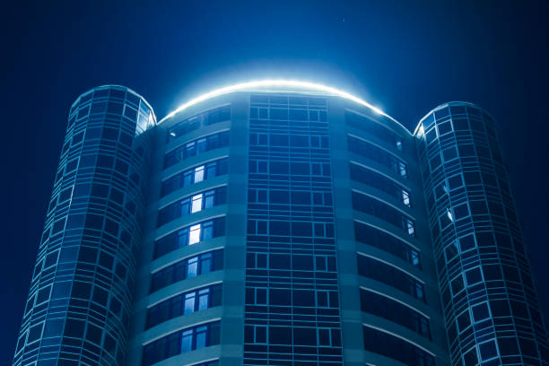 Bottom angle shooting  modern urban building with neon light against the night sky stock photo