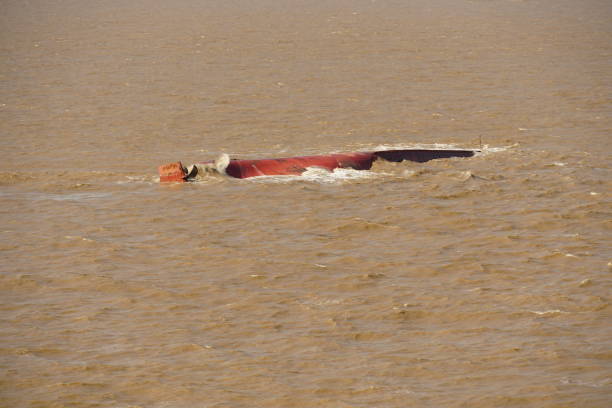 Bottom of the capsized ship in the muddy river approaching to  the Shanghai, China. Bottom of the capsized ship with rudder and propeller in the muddy river approaching to the Shanghai, China. capsizing stock pictures, royalty-free photos & images