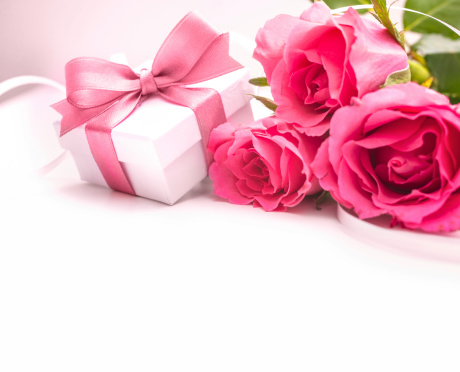Bouquet of roses and gift box on white background