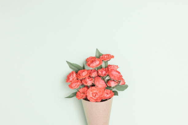 bouquet von roten rosen in vintage-papier auf dem tisch. - blumenbouqet stock-fotos und bilder