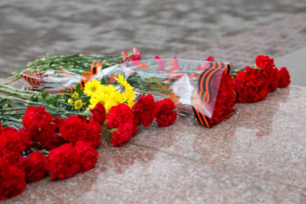 Bouquets of flowers lie on granite in the Victory Memorial during the celebration of Victory Day in the WWII Spring landscape. Bouquets of flowers lie on granite in the Victory Memorial during the celebration of Victory Day in the WWII of Krasnoyarsk city.  Krasnoyarsk Region. Russia. granitic stock pictures, royalty-free photos & images
