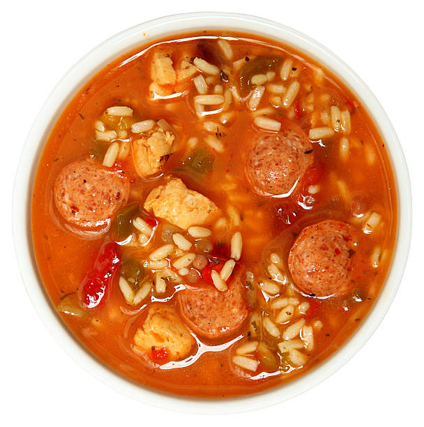 Bowl of Cajun Spicy Chicken and Sausage Gumbo Soup Bowl of Cajun Spicy Chicken and Sausage Gumbo Soup Over White gumbo stock pictures, royalty-free photos & images