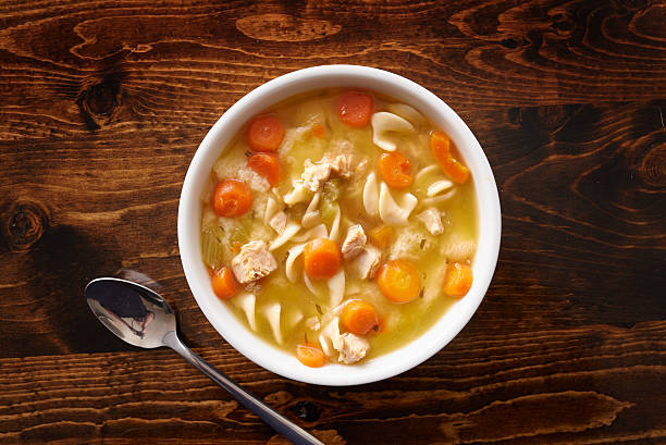 bowl of chicken noodle soup shot top down stock photo