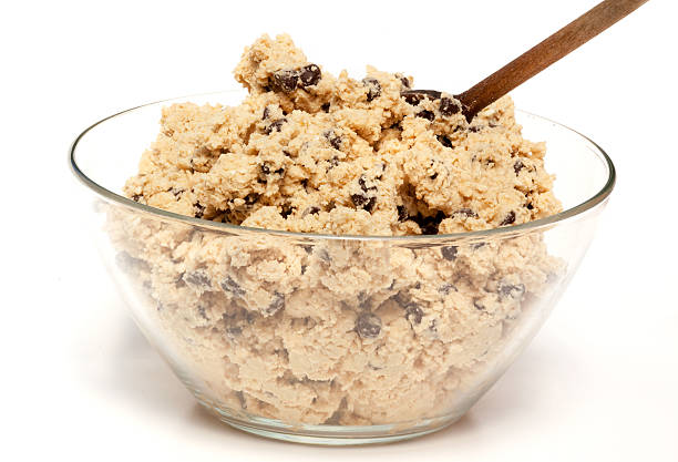 Bowl of cookie dough with a wooden spoon and chocolate chips stock photo
