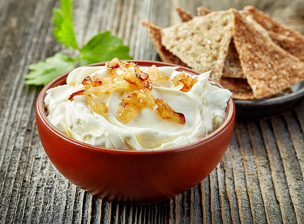 bowl of cream cheese with caramelized onions bowl of cream cheese with caramelized onions on wooden table dipping sauce stock pictures, royalty-free photos & images
