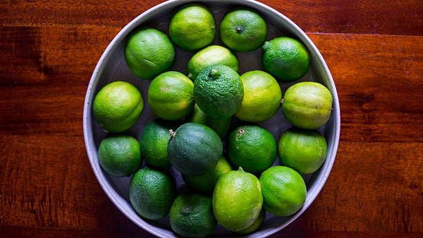 Bowl of Fresh Limes On Table stock photo
