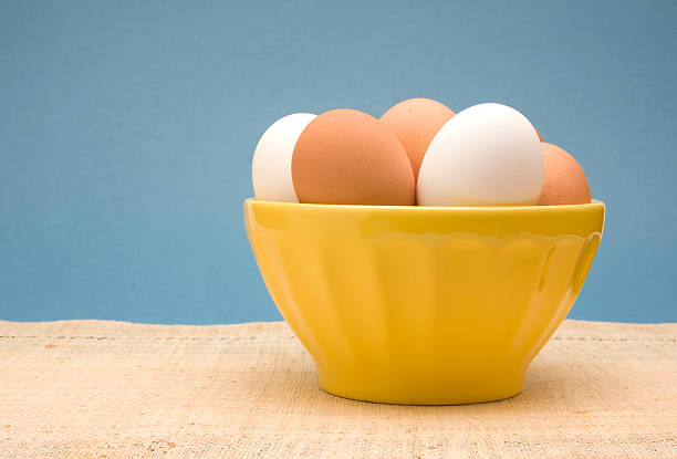 Bowl of Fresh White and Brown Eggs stock photo