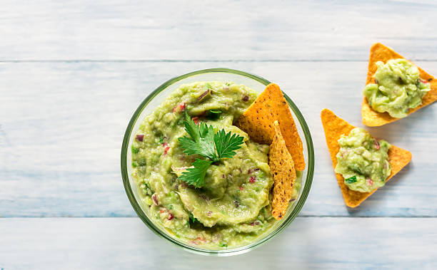 Bowl of guacamole with tortilla chips Bowl of guacamole with tortilla chips guacamole stock pictures, royalty-free photos & images