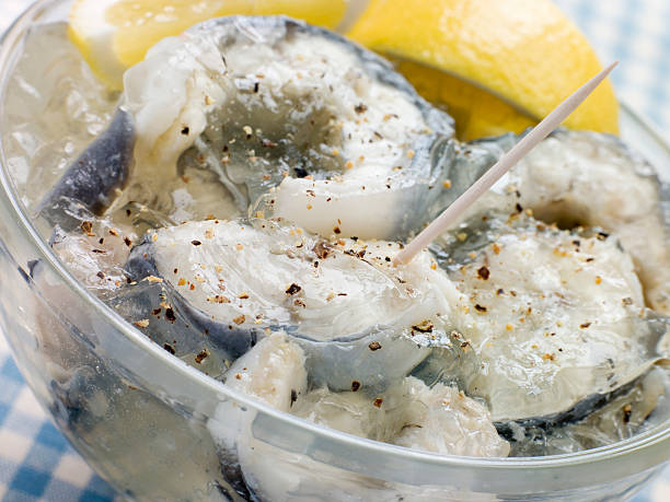 Bowl of Jellied Eels Bowl of Jellied Eels and Lemon Wedge gelatin dessert stock pictures, royalty-free photos & images