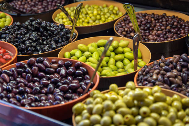 Bowls of green and black olives on display on a market stall stock photo