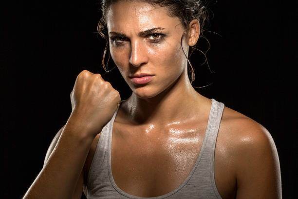 Boxer fighter MMA tough woman athlete exercise training champion intimidating stock photo