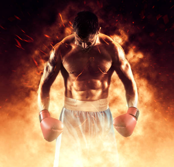Boxer in red gloves on fire background stock photo