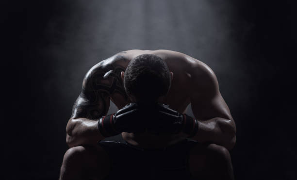 Boxer Boxer athlete sits with a drooping head on a black background defeat stock pictures, royalty-free photos & images