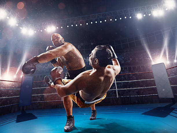 Boxing: extremely powerful punch The action takes place on a professional ring with high weight sportsmen.  All wear unbranded cloth and sport equipment boxing ring stock pictures, royalty-free photos & images